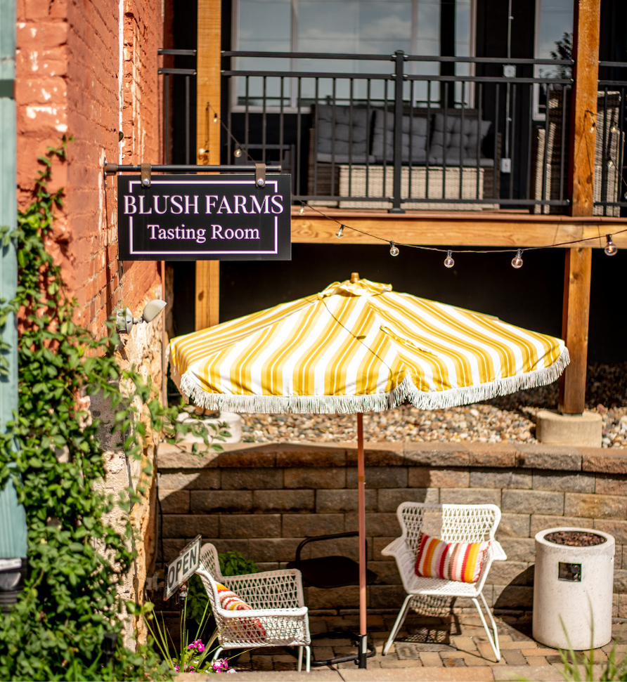 Yellow striped umbrella and chairs outside tasting room in Liberty