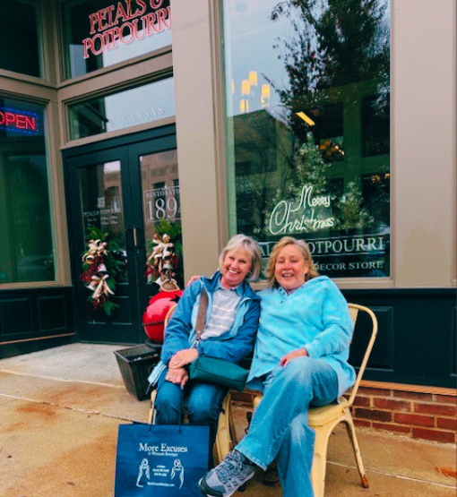two female senior citizens Christmas shopping on a historic swuare